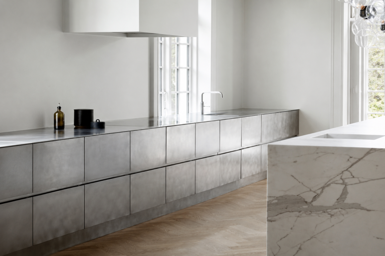 Cuisine contemporaine avec meubles en inox brossé, îlot en marbre et parquet en chêne massif