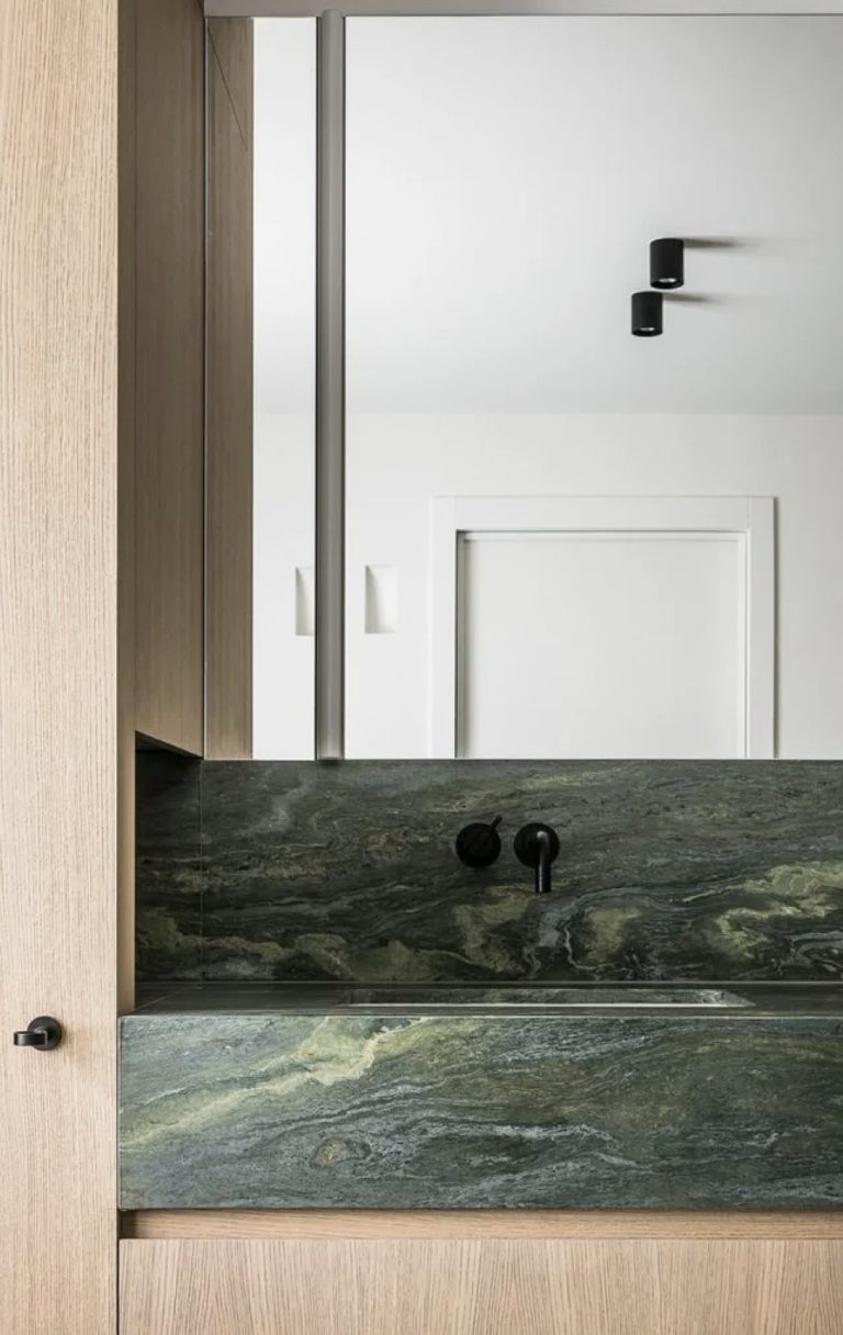 Salle de bains contemporaine avec vasque en marbre et finitions en pierre naturelle