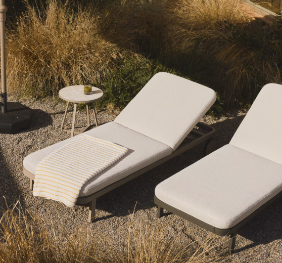Bains de soleil design avec coussins écrus sur une terrasse contemporaine