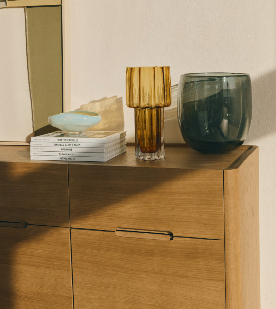 Centre de table décoratif avec vase en verre et objets design sur un meuble en bois