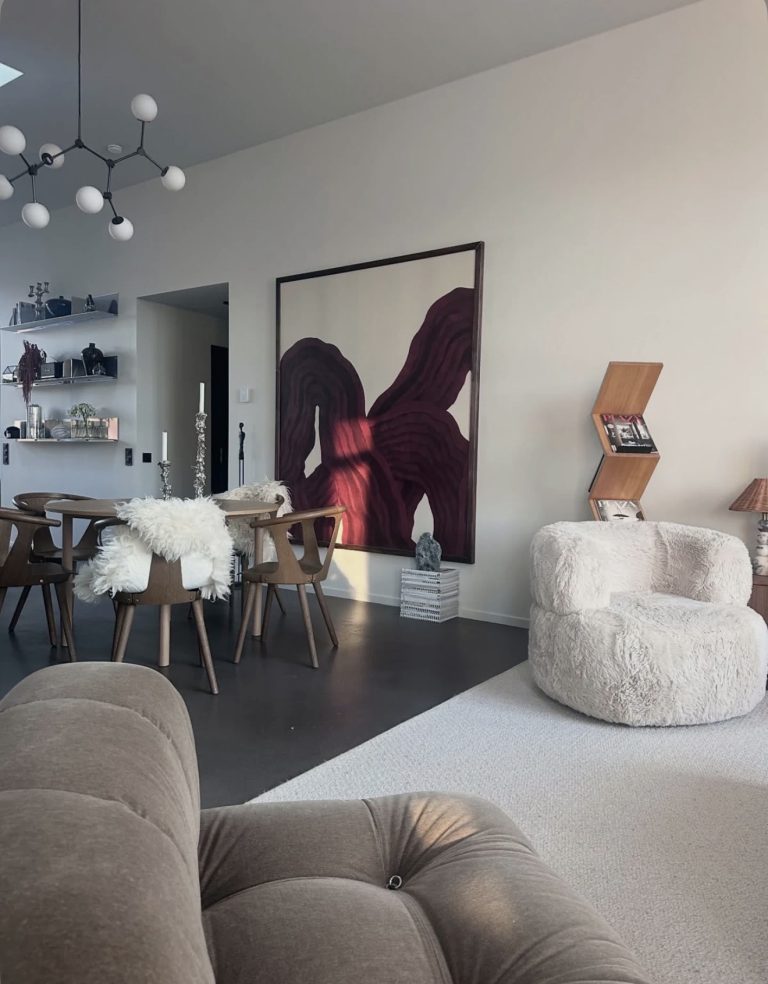 Salon contemporain avec fauteuils design, table basse en pierre et décoration minimaliste