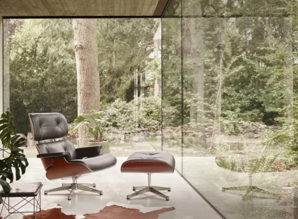Fauteuil lounge en cuir avec repose-pieds dans un intérieur contemporain ouvert sur la nature