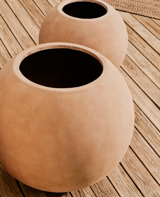 Pot en terre cuite aux formes arrondies posé sur une table en bois