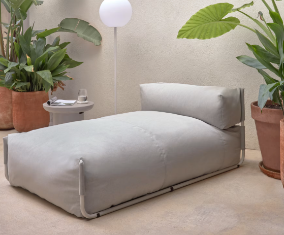 Pouf d'extérieur en tissu beige sur une terrasse contemporaine avec plantes tropicales